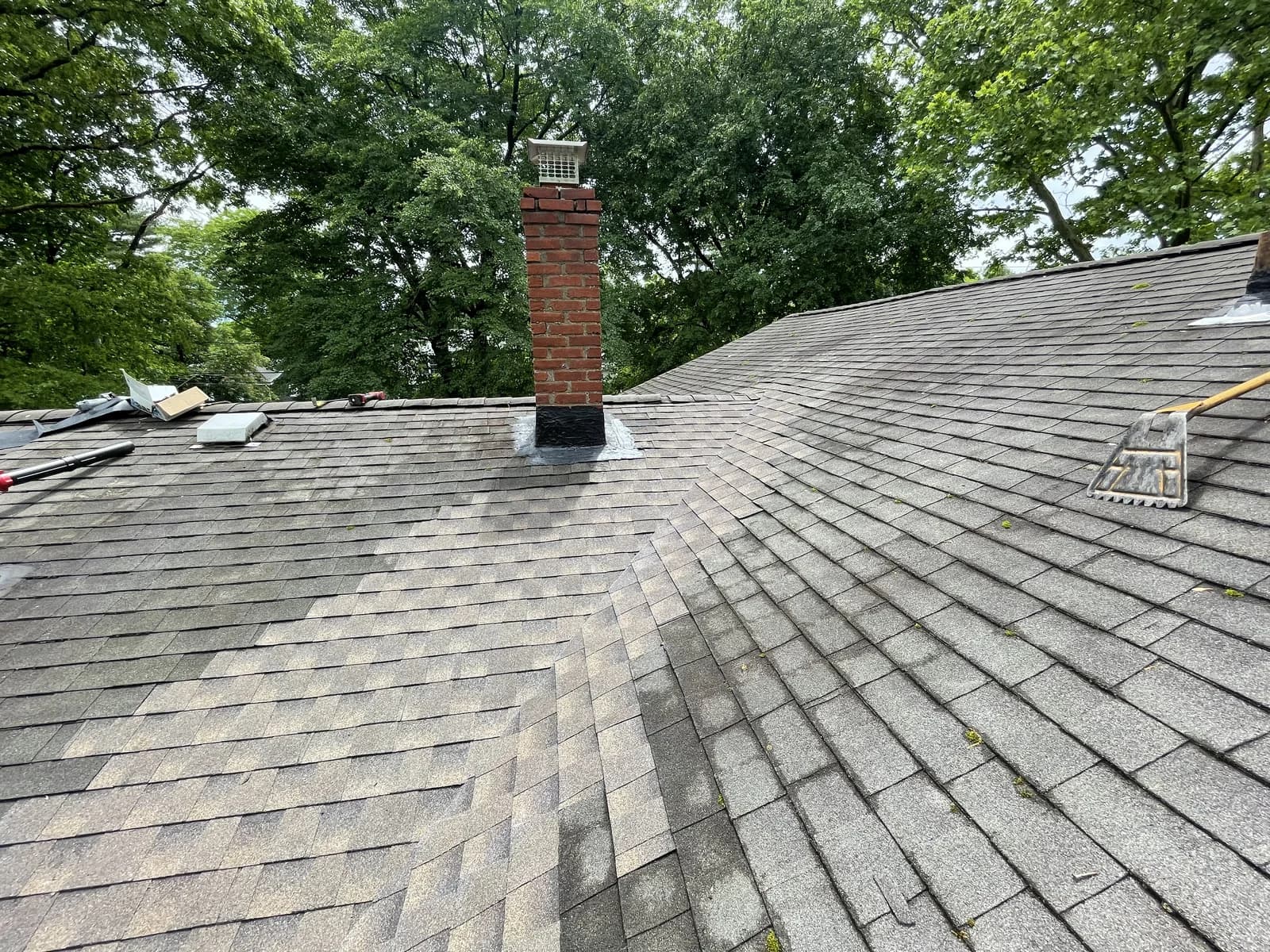 Same roof after full replacement — new architectural shingles and repointed chimney